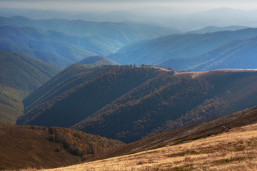 Autumn landscapes with fantastic mountain views of the Ukrainian Carpathian mountains with morning and evening sky and slopes with yellow-red trees.