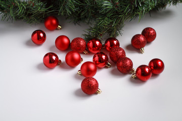  96 / 10000 АНГЛИЙСКИЙ Перевести вGoogleBing red Christmas balls and decorations for Christmas next to an artificial green Christmas tree on a light background