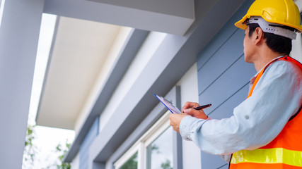 The inspector or engineer is checking the building structure and house roof specifications. After...