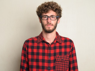 Face of young bearded hipster man with curly hair