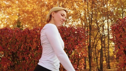 Beautiful woman training ballet pas on outdoor class in autumn park. Ballet woman group training choreography exercise in city park. Fit woman practicing port de bras