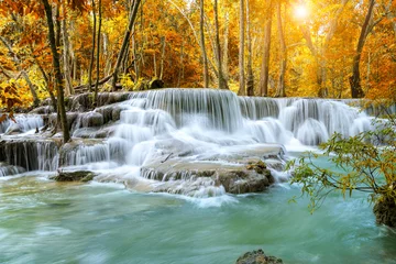 Raamstickers Colorful majestic waterfall in national park forest during autumn - Image © wirojsid