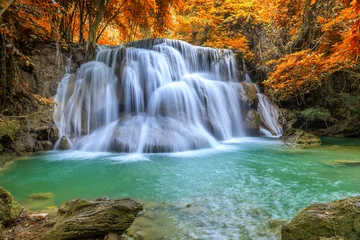 Rolgordijnen Mooie en kleurrijke waterval in diep bos tijdens idyllische herfst © wirojsid