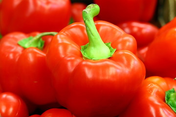Red bell peppers on a counter in the supermarket. A large number of red peppers in a pile
