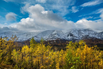 Mountain landscape. Rocky shore of a mountain lake on a rainy autumn day. First snow