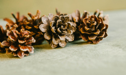 A lot of fir cones lies on a beige background. Winter concept.