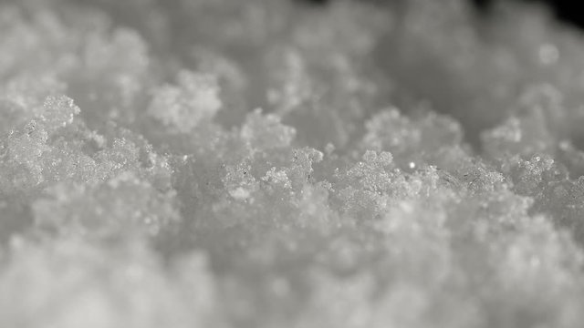 Snow accumulating on a windowpane, falling snowflakes closeup