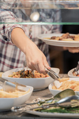 Girl whose face is not seen choosing food which has in front placed in a showcase concept of healthy food.