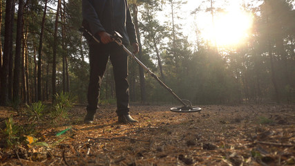 man with metal detector in forest