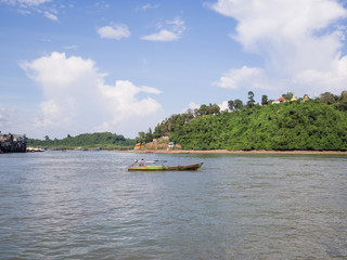 Fototapeta premium A long tail boat sailed in the middle of the sea passing through an island that has temples