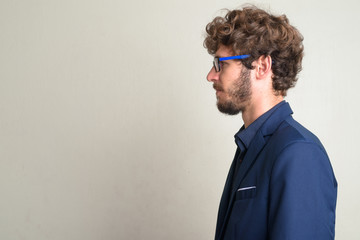 Closeup profile view of young bearded businessman with eyeglasses in suit