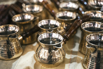 Turkish copper coffee pots with ornaments on a counter in a Turkish bazaar