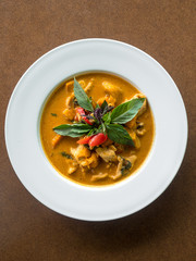 Hearty and warming chicken curry with fresh basil and vegetables. A spicy soup dish served in a Thai food restaurant. 