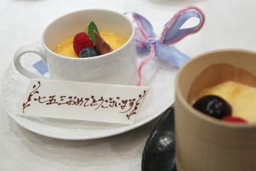 七五三　 dessert  pudding with congratulation message on white chocolate when it is Japanese traditional  celebration event ,Translation [ 7 and 5 and 3 years old congratulations]