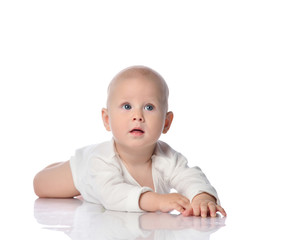 Infant child baby toddler in white shirt lying on his stomach looking up, quiet, his attention is captured by something