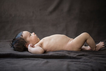 A cute little baby boy laying in bed