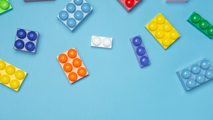 Colorful toy blocks on blue background. Flat lay. Copy space for text