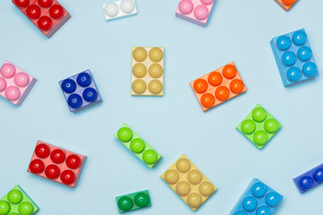 Colored toy bricks on a blue background. Flat lay