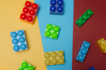 Toy bricks. Multicolored plastic building blocks. Background of plastic colored details building blocks. Top view