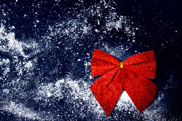 Red festive decorative bow on dark blue background. Blank for writing Christmas or new year baking recipes. Copy space.