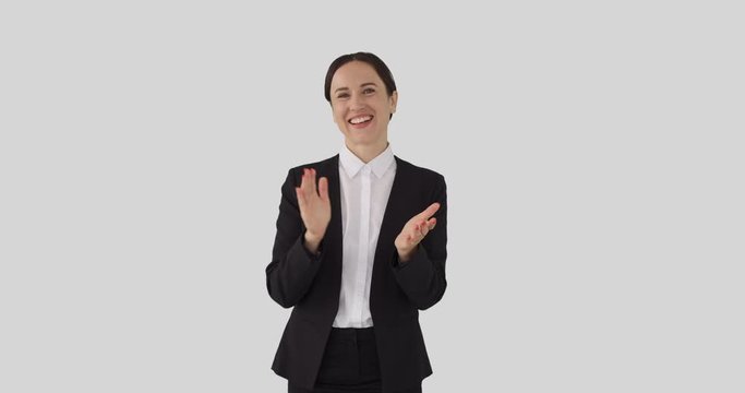 Smiling businesswoman clapping hands over white background