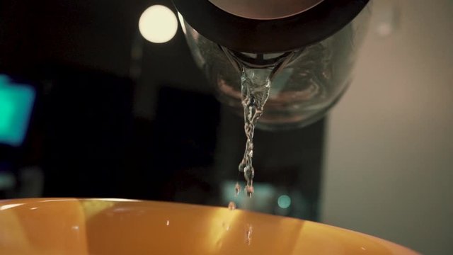 Pouring water on jelly powder in yellow bowl in slow motion