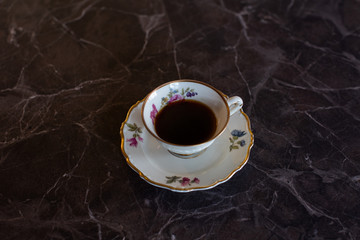 Black coffee served in an elegant, old china. Espresso in beautiful porcelain cup.