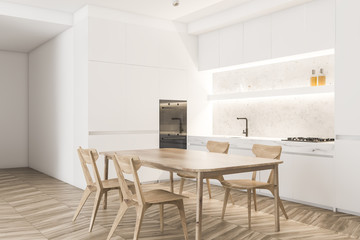 White kitchen corner with wooden table