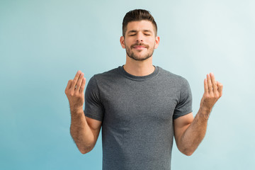 Young Man Practicing Breathing Exercise and Meditating