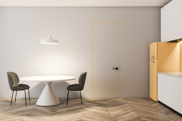 Light gray kitchen with fridge and round table
