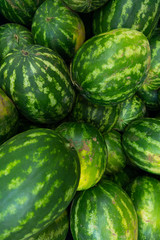 watermelon with stripe pattern for background at farmer's market or grocery store, vertical photo