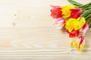 Bunch of Colorful tulip flowers on wooden table background with space for text