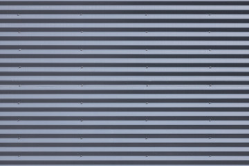 Fototapeta premium Close-up of grey metal corrugated wall in daylight
