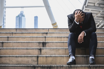 Business people are stressed, put their hands on the head about unemployment, stress, work hard, have a big city backdrop