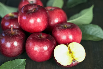 bunch of red apples close-up. background with ripe apples and leaves. whole apples and half apples.