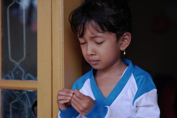Little Asian girl showed sad expression. Cute Indonesian kid. 