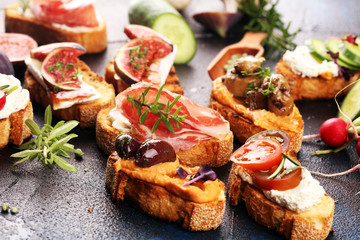 Assorted bruschetta with various toppings. Appetizing bruschetta or brie crostini. Variety of small sandwiches. Mix bruschetta on table