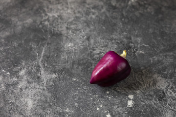 Fresh vegetables. Purple pepper on a dark background