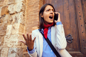  angry businesswoman working and talking on phone at street.