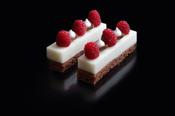 White mousse desserts with raspberries and meringues on brownie base