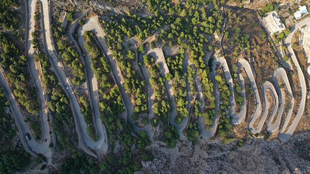 Aerial drone top down photo of snake serpentine narrow road leading uphill