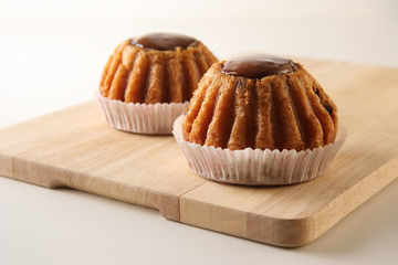 Closeup of two freshly baked delicious rum cakes with raisin on the wooden board, horizontal image, selective focus on foreground