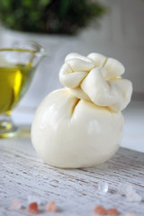 Burrata, Italian fresh cheese made from cream and milk of buffalo or cow. Close-up. Delicate delicacy on a white background.