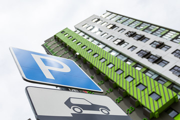 Obraz premium Bottom view of roadsign Way of parking vehicle against new block of flats
