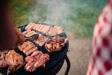 POV photo of men barbecuing chicken meat