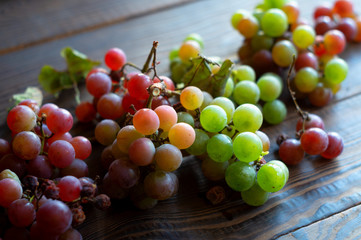 Ripe green and red grapes on a wooden table