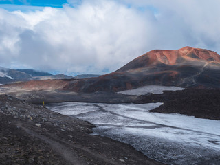 Red and black volcanic Iceland landscape at Fimmvorduhals hiking trail with glacier volcano lava field, snow and magni and mudi hill, createed by eruption of Eyjafjallajokull in 2010 which affected