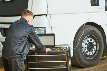 Truck repair service. Mechanic makes computer diagnostic of the semitruck