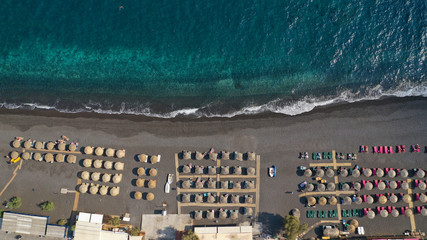 Aerial drone top down photo of famous seaside village and organised with sun-beds and umbrellas...