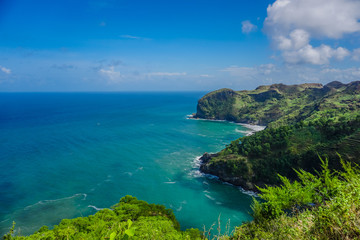 View of landscape ocean and nice green hill on white clouds and Blue sky background. Kebumen, Central Java, Indonesia